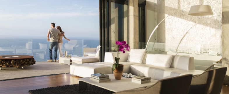 Open modern living room with view of the ocean at dusk